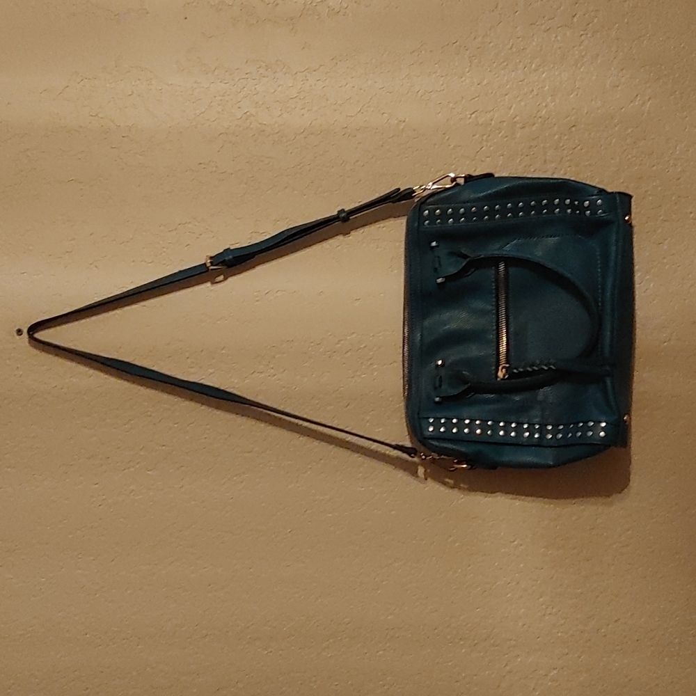 Purse with adjustable strip. The purse is teal in color.